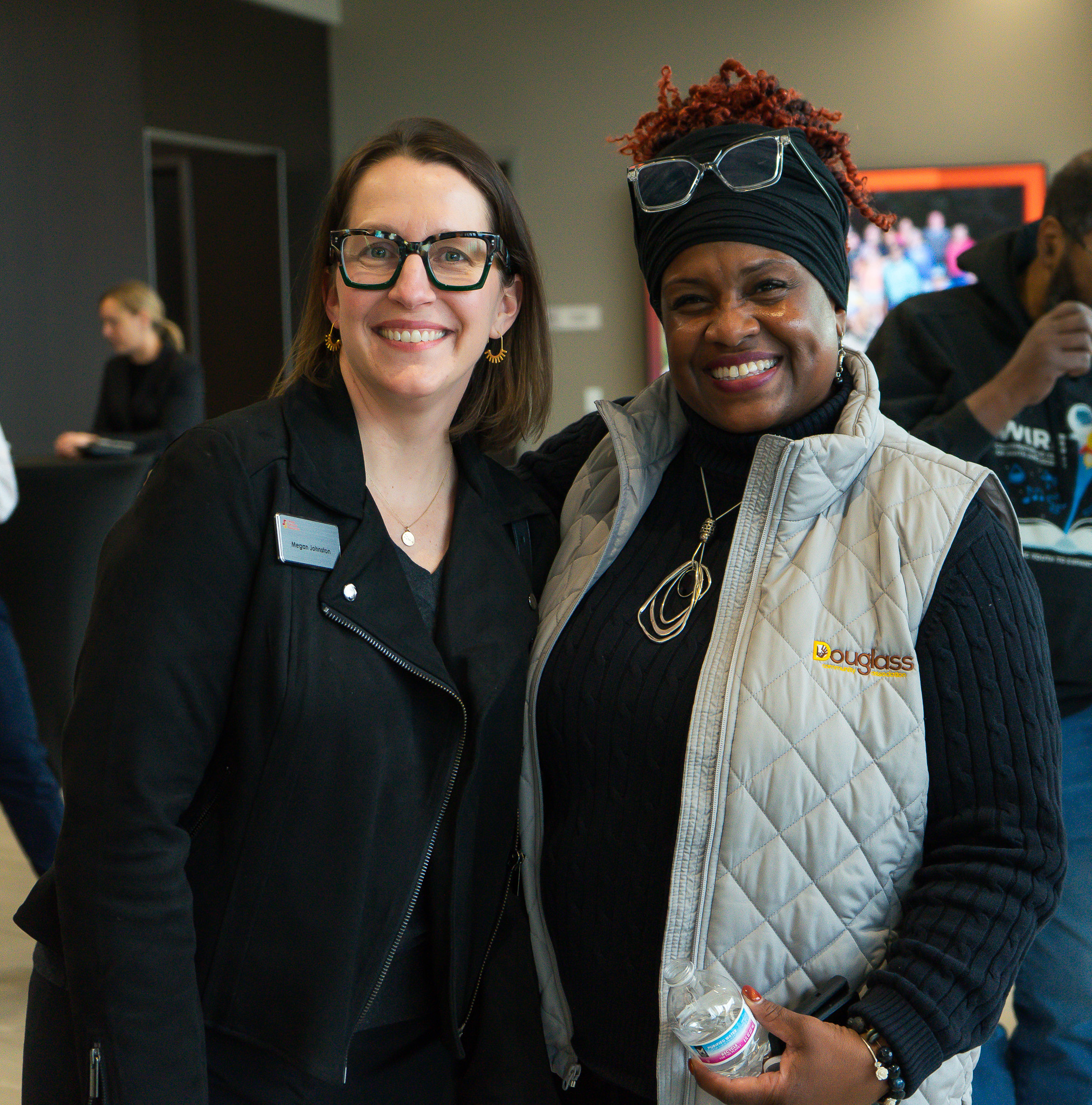 Two community partners smiling together at a local gathering